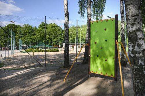 a green rock wall in a park with trees at Best Western Plus Hotel Olsztyn Old Town in Olsztyn