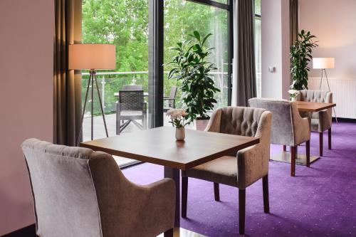 a room with tables and chairs and a large window at Best Western Plus Hotel Olsztyn Old Town in Olsztyn