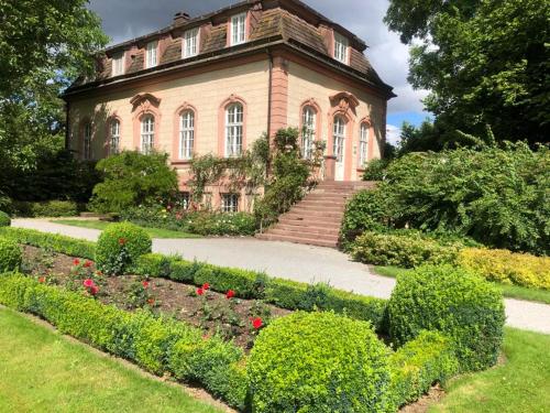 una casa antigua con un jardín delante de ella en Teehaus im Schlosspark Weltkulturerbe Corvey, en Höxter