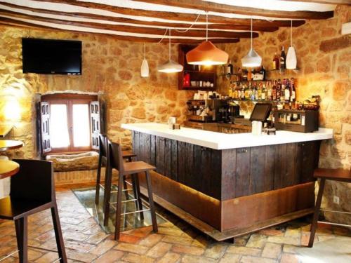 a bar with a counter and chairs in a room at Hotel Rural LATORRIÉN DE ANE in Mues