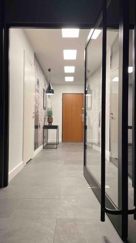 an office hallway with glass doors and a wooden door at MagSpace River View Jacuzzi Apartment Free Parking in Gdańsk