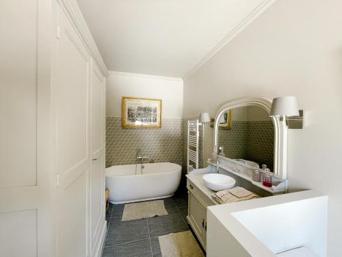 une salle de bain blanche avec une baignoire et un lavabo dans l'établissement Château du Domaine du Réveillon, à Entrains-sur-Nohain