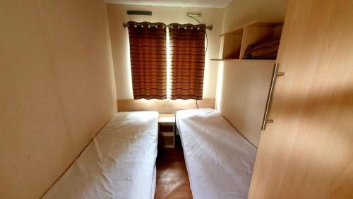 a small room with two beds in front of a window at Domek holenderski święty spokój Bieszczady in Ropienka