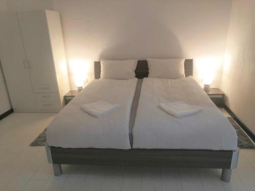 a bedroom with a large bed with two pillows at SMART GuestHouse in Oradea