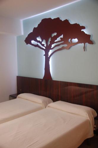 a room with two beds with a tree on the wall at Sol Playa in Valencia