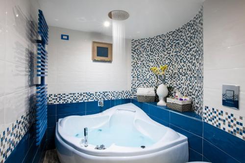 y baño azul y blanco con bañera. en YourHome - Casa Barba Positano en Positano