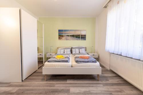 a bedroom with two beds and a mirror at Haus Kormoran Borkum in Borkum