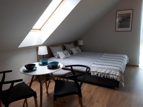 a bedroom with a bed and a table with chairs at Sosenka in Niechorze
