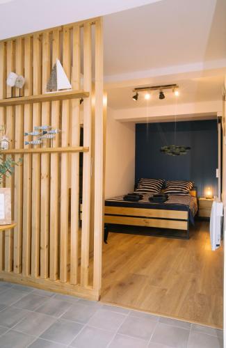 une chambre avec un lit et un mur en bois dans l'établissement Appartement climatisé - Bleu Azur - hyper-centre de Toulon, à Toulon