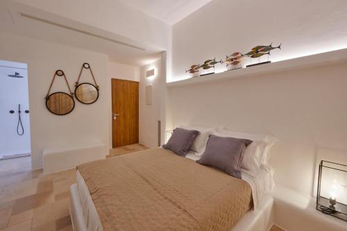 a bedroom with a large bed in a white room at Musae al Mare in Polignano a Mare