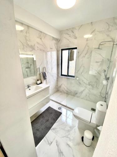 a white bathroom with a toilet and a sink at Vivenda Sossego do Mar in Ferragudo