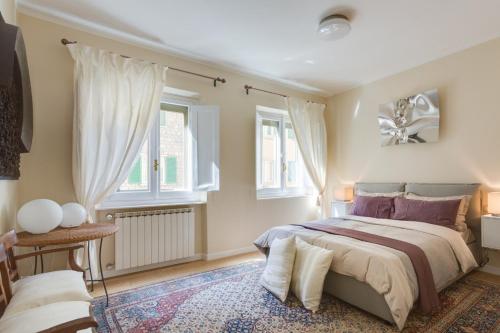 una camera con un letto e due finestre di Apartment Ponte Vecchio Balcony a Firenze