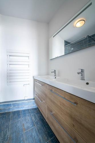 a bathroom with a sink and a mirror at Résidence Le Crystal Dinard Plage in Dinard