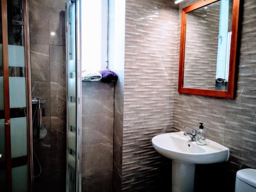 y baño con lavabo, espejo y ducha. en ADOSADO NUEVA OROPESA, en Oropesa del Mar