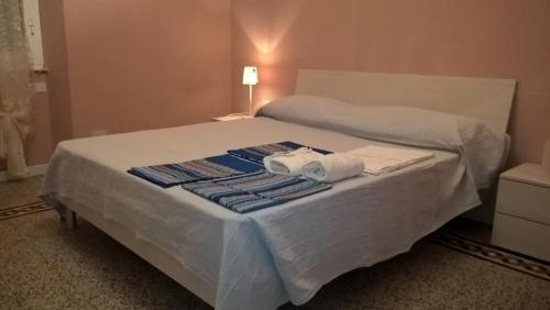 un letto bianco con due asciugamani sopra di Casetta Stazione Filo di Arianna a La Spezia