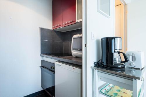 a small kitchen with a counter and a microwave at Résidence Le Crystal Dinard Plage in Dinard