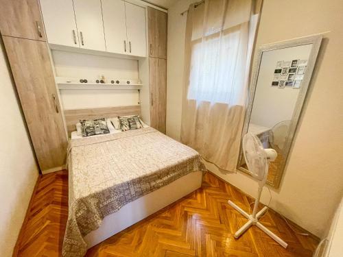 um pequeno quarto com uma cama e uma janela em Apartman Lu&Ni em Dramalj