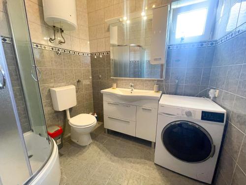 ein Badezimmer mit Waschmaschine und Waschbecken in der Unterkunft Apartman Lu&Ni in Dramalj