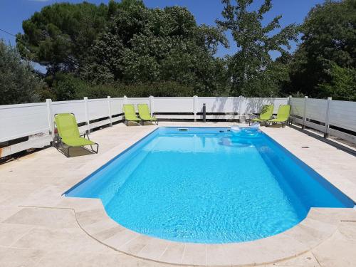 une grande piscine avec des chaises et une clôture dans l'établissement Chambre d'hôtes Costa Belle, à Lunel-Viel