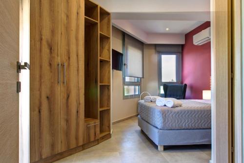 a bedroom with a bed and a large wooden door at Tessera Villas & Studios Collection in Gouvia