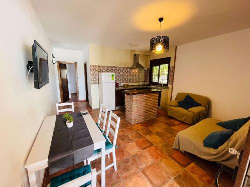 una cucina e un soggiorno con tavolo e sedie di El Refugio 2 a Los Caños de Meca