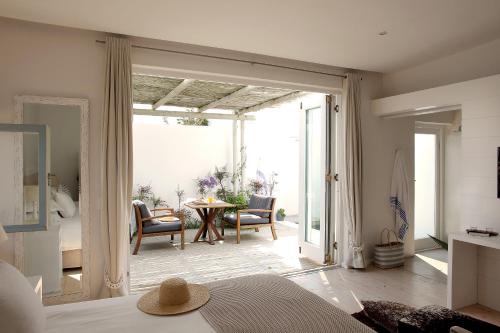 a bedroom with a door open to a patio at Strandloper Ocean Boutique Hotel in Paternoster