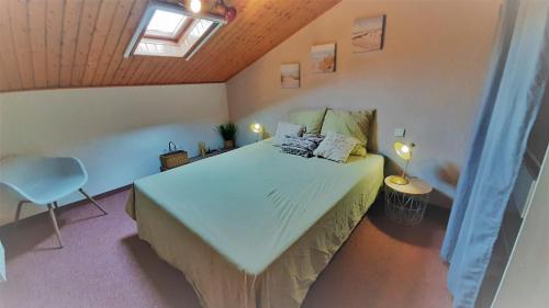 une chambre avec un grand lit dans un grenier dans l'établissement L'ESCAPADE maison 3 chambres plus mezzanine 8 à 10 personnes, à Saint-Jean-de-Monts