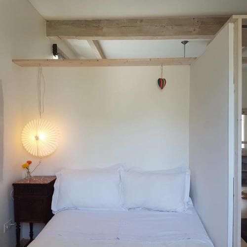 a bedroom with a white bed with a wooden ceiling at The Mill France- Near Millau in Saint-Georges-de-Luzençon