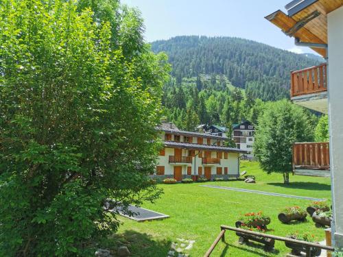 a view of a building with a green yard and trees at Appartamento Elda La Thuile in La Thuile