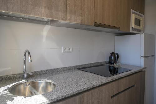 a kitchen counter with a sink and a refrigerator at Albatros Family in Salou