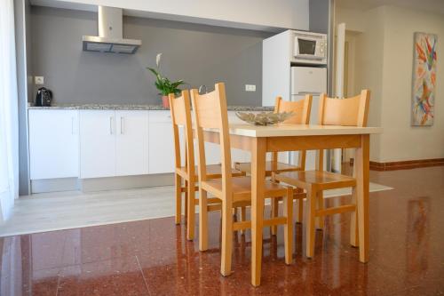 a kitchen with a wooden table and chairs at Albatros Family in Salou