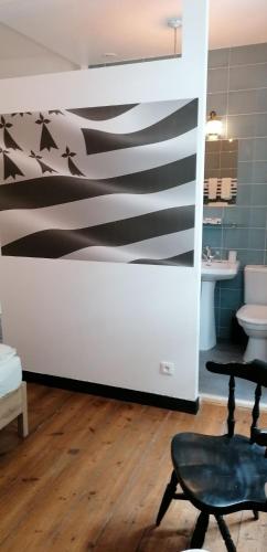 a bathroom with a black and white wall at Le Derrien in La Roche-Derrien