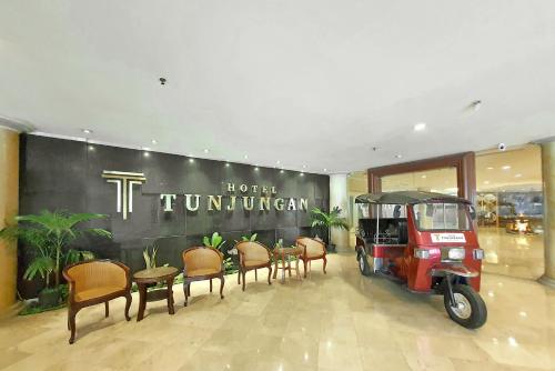 a golf cart in a room with tables and chairs at Tunjungan Hotel in Surabaya