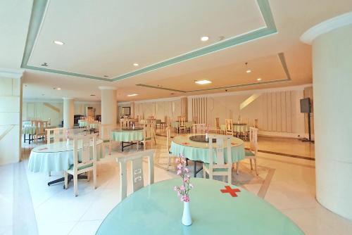 a dining room with tables and chairs and a room with tables and chairs at Tunjungan Hotel in Surabaya