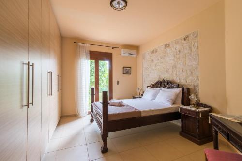 Un dormitorio con una cama en una habitación con ventana. en Heraklion Comfy House with Mountain View, en Heraclión