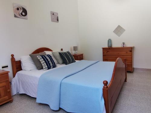 托雷戴科爾薩里的住宿－Oro Tramonto，一间卧室配有一张带蓝色毯子的大床