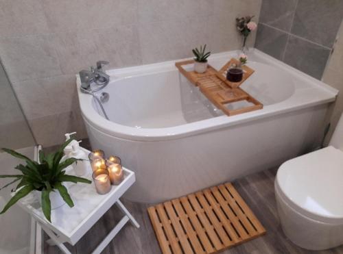 a bathroom with a white tub and a toilet at Sunny-side-up in St Austell