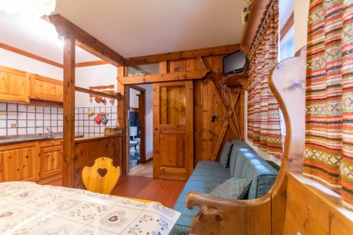 una habitación con sofá y mesa en una casa en Ski Residence 3B en Falcade