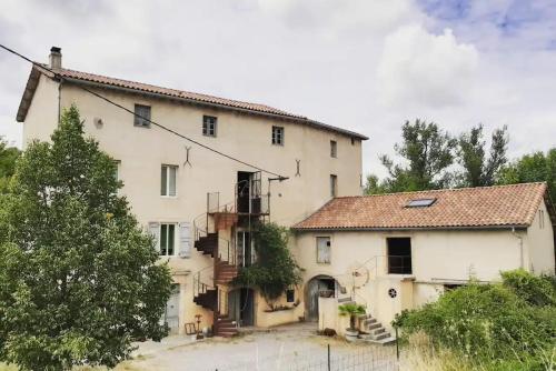 a large white house with a staircase in front of it at The Mill France- Near Millau in Saint-Georges-de-Luzençon