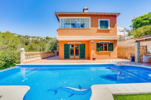 una casa con piscina di fronte a una casa di Villa Portals Nous 2 a Portals Nous