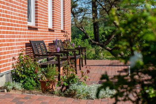 a group of black benches sitting in front of a brick building at Hotel MeerLand Pellworm in Pellworm