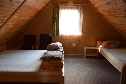um quarto no sótão com 2 camas e uma janela em Ośrodek Wypoczynkowy Babiński em Władysławowo