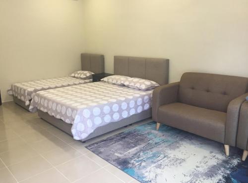 2 Betten und ein Sofa in einem Zimmer in der Unterkunft CASA ADELIA STUDIO CHUKAI KEMAMAN in Cukai