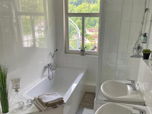 biała łazienka z wanną i umywalką w obiekcie Grafenburg, Residenz Kaiserreich w mieście Kiefersfelden