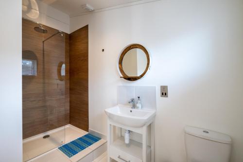 a bathroom with a sink and a toilet and a mirror at Edge of Padstow, 2 bedroom luxury lodge in Padstow