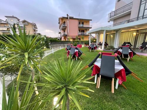 a group of tables and chairs in a yard at Hotel Le Ceramiche in Montalto Uffugo
