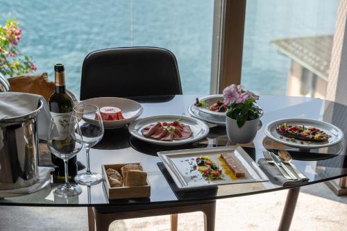 a table with plates of food and a bottle of wine at Grand Hotel Campione in Campione dʼItalia