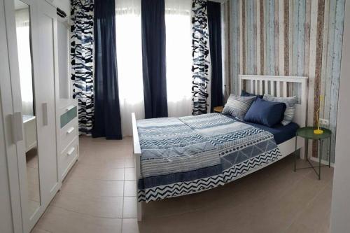 a small bedroom with a bed and a window at Apartment Beach Kavatsi in Sozopol