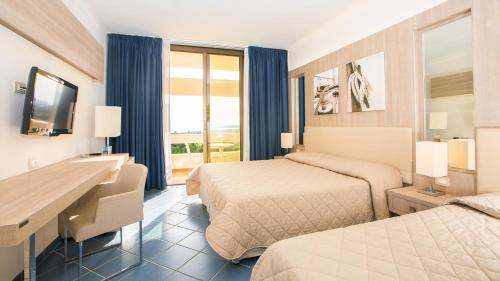a hotel room with two beds and a desk at MClub Lipari in Sciacca