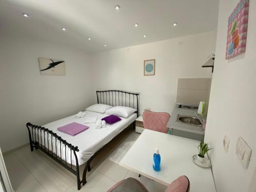 a small bedroom with a bed and a table at Apartment Anna in Zadar